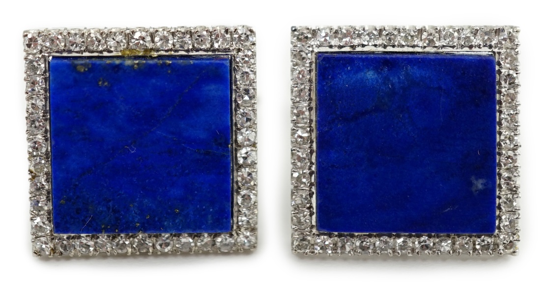 A pair of 18K white metal, lapis lazuli and diamond set tablet cufflinks, each lapis stone surrounded by forty claw set diamonds, 17mm, gross weight 14.1 grams. Condition - fair